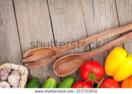 Fresh ripe vegetables and utensils on wooden table with copy space