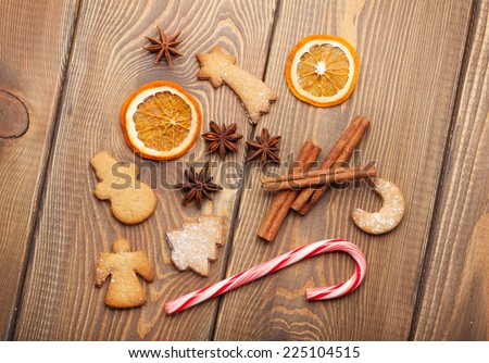 Christmas food decoration with gingerbread cookies, spices and candies. View from above on wooden background