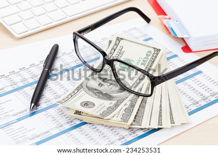 Office table with computer, supplies, reports and money cash