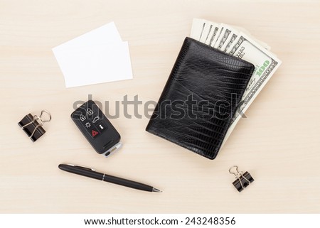 Money cash wallet and car remote key on wooden table. View from above with business cards for copy space