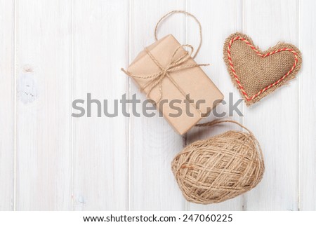Valentines day gift wrapping over white wooden table with copy space