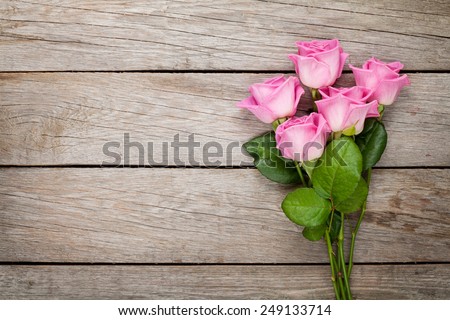 Valentines day background with pink roses over wooden table. Top view with copy space