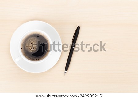 Office desk with coffee cup and pen. View from above with copy space
