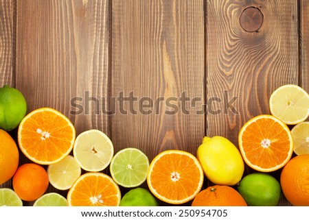 Citrus fruits. Oranges, limes and lemons. Top view over wooden table background with copy space