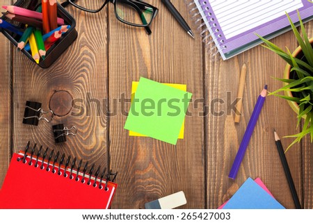 Office table with flower, supplies and blank post it for copy space