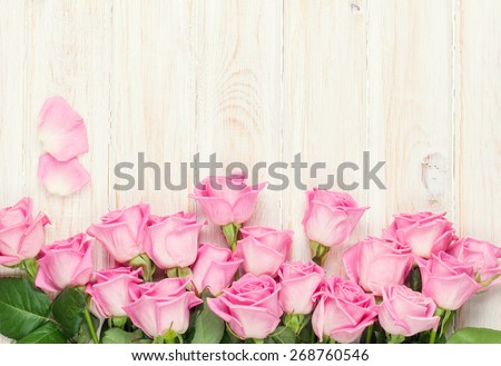 Pink roses bouquet over wooden table. Top view with copy space