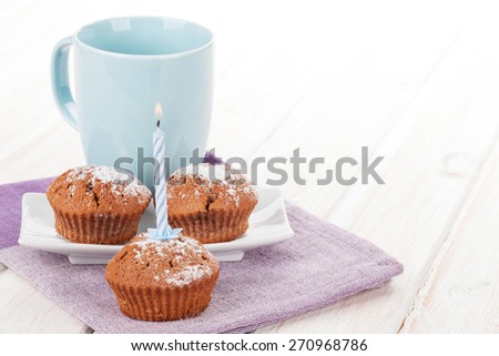 Cup of milk and cakes on white wooden table
