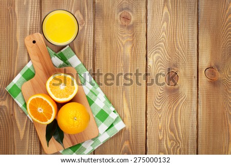 Oranges and glass of juice. View from above over wood table background with copy space