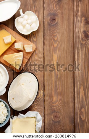 Dairy products on wooden table. Sour cream, milk, cheese, yogurt and butter. Top view with copy space