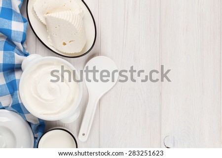 Dairy products on wooden table. Sour cream, milk and cheese. Top view with copy space