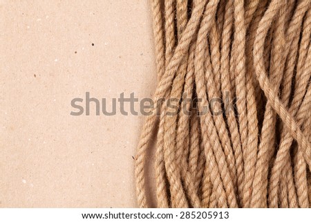 Brown cardboard paper background with marine rope and copy space