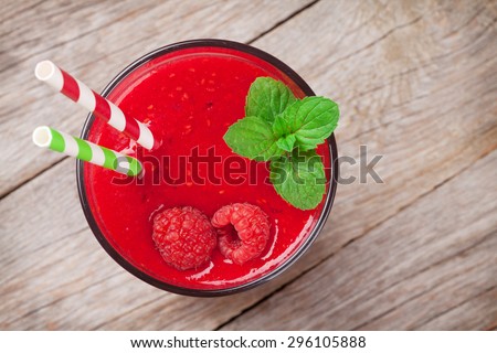 Raspberry smoothie with berries on wooden table. Top view