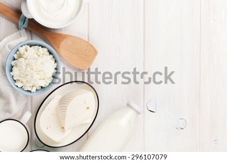 Dairy products on wooden table. Sour cream, milk, cheese and yogurt. Top view with copy space