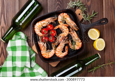 Grilled shrimps on frying pan and beer. Top view