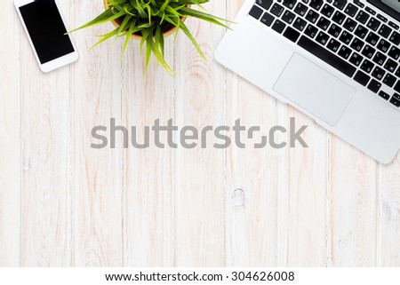 Office desk table with laptop computer and flower. Top view with copy space