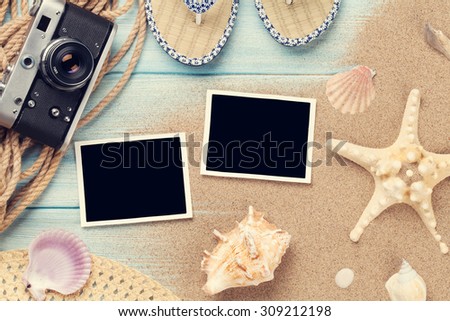 Travel and vacation photo frames and items on wooden table. Top view