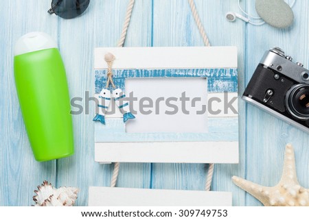 Travel and vacation photo frame and items on wooden table. Top view