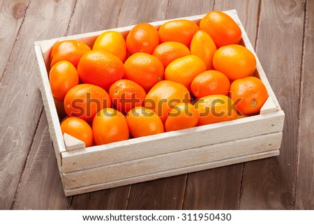 Orange tomatoes box on wooden table