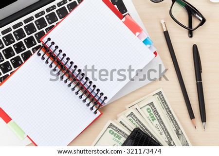 Office table with pc, supplies and money cash. View from above with notepad for copy space