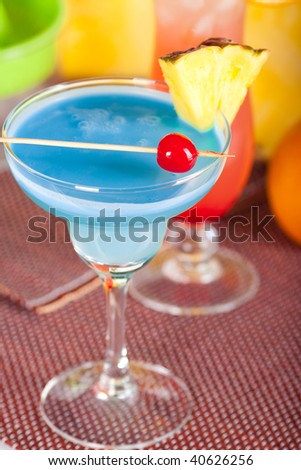 Two tropical cocktails with pineapple, orange and cherry