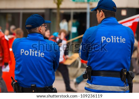 ANTWERP, BELGIUM - MAY 1: Two Flemish Policemen watch over marchers and keep the peace at the annual May Day Parade on May 1, 2010 in Antwerp, Belgium