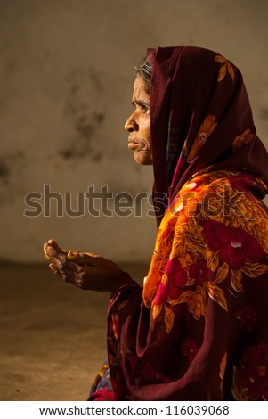 BIJAPUR, INDIA - FEBRUARY 19: An unidentified Indian woman begs with her hands out at the entrance of a mosque on February 19, 2009 in Bijapur, India. Poverty is a major social issue in India