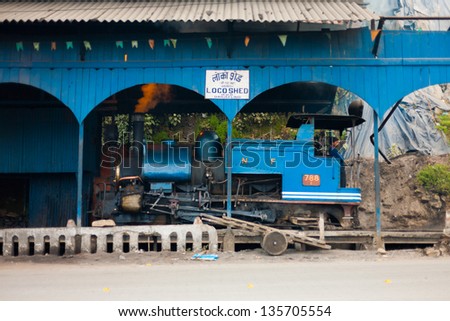 DARJEELING, INDIA - DECEMBER 27: An unidentified Indian driver stands in a parked toy train engine, a tourist attraction, in its shed on December 27, 2007 in Darjeeling, India