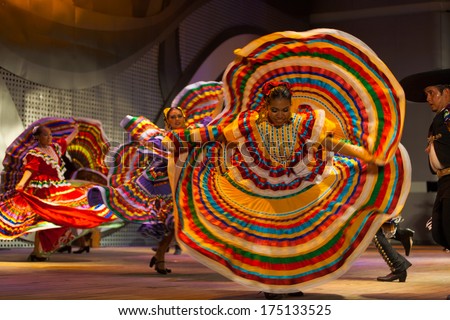 SEOUL, KOREA - SEPTEMBER 30, 2009: An unidentified female Mexican dancer spins and spreads her colorful yellow dress during a traditional folk show at a public outdoor stage at city hall