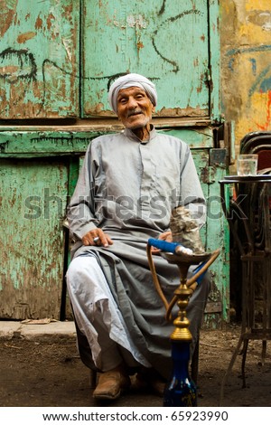 CAIRO - OCTOBER 11: An unidentified old Egyptian man sits at a street cafe smoking sheesha in Islamic Cairo October 11, 2010 at Cairo, Egypt