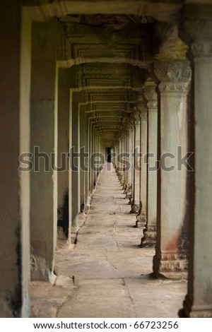 The beautiful repetititive series of carved stone pillars that surrounds the inner wall of Angkor Temple