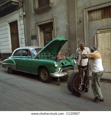 Two men standing in front of a car, Havana, Cuba