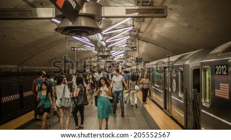 NEW YORK - JULY 14, 2014: crowded MTA subway train station platform with people traveling in New York. The NYC Subway is a rapid transit/transportation system in the City of NY.