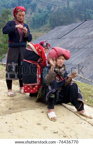 SAPA, VIETNAM - NOV 22: Unidentified women from the Red Dao Ethnic Minority People sitting on trail on November 22, 2010 in Sapa, Vietnam. Red Dao are the 9th largest ethnic group in Vietnam