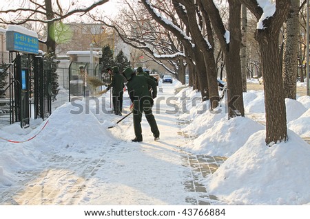 BEIJING - JANUARY 4: Military personnel clear off the snow of a sidewalk on January 4, 2010 in Beijing, China. The heaviest snow in about half a century blanketed this city yesterday.