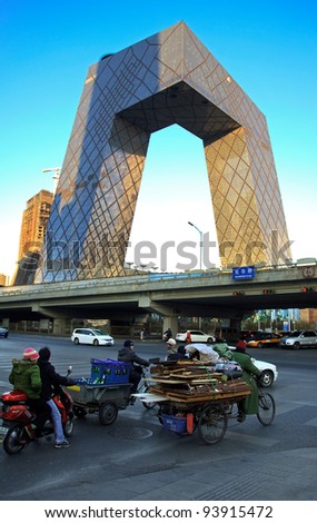 BEIJING-JANUARY 1: Workers and locals cycle around China Central Television (CCTV) Headquarters, a 234 m skyscraper, at dusk on Jan 1, 2011 in Beijing, China. CCTV is the National TV station of China.