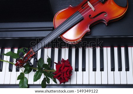 Piano keyboard, red rose and  violin