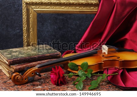 Violin, red rose, burning candle, drapery and old books