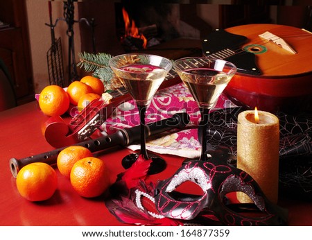 Masquerade still-life. Colorful Venice masks, two glasses of wine, fruits, burning candle