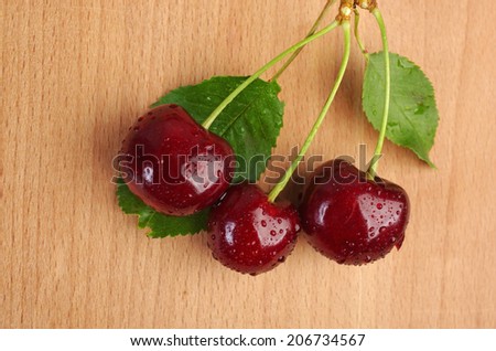 Sweet cherries with water drops on wooden table
