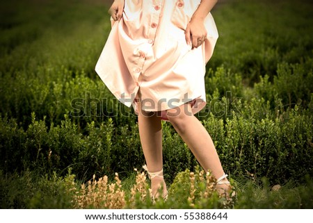 Woman in a retro dress standing in the middle of a field