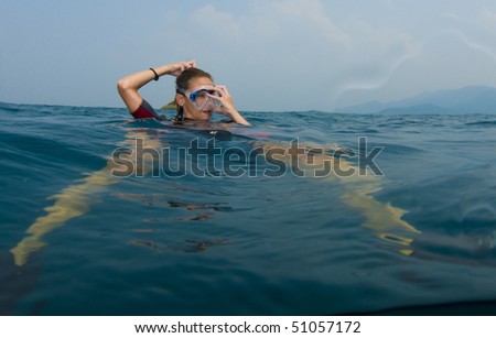 female scuba diver on surface trying on mask
