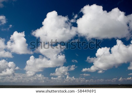 Nature background with white cumulus clouds on blue sky