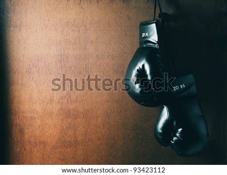 Boxing glove hanging on wooden grunge background