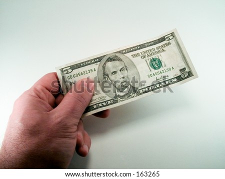 Man holding a five dollar bill.