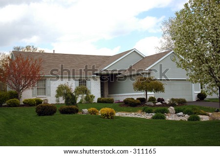A ranch house with a fantastic landscaped lawn.