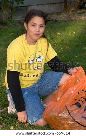 Girl stuffing Halloween bag with leaves