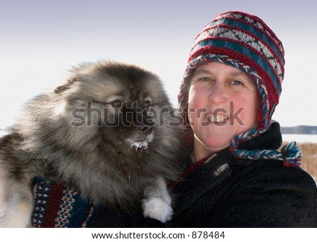 A woman with her dog on a sunny morning after a snow fall
