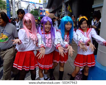 BANGKOK, THAILAND- AUGUST 4: Asian girls dressed in bright clothing pose for photographers outside the MBK shopping center on August 4 2007 Central Bangkok.