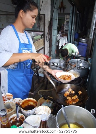 BANGKOK, THAILAND - MAY 16: Thai woman cooking food in an outdoor kitchen May 16, 2005 in Bangkok.