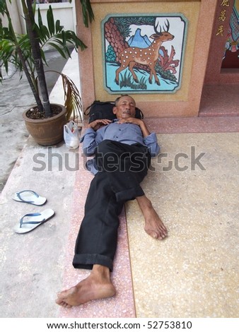 BANGKOK, THAILAND - MAY 16: Thai old man sleeping outside a Chinese temple May 16, 2005 in Bangkok.